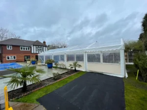 Marquee set up in a garden next to a swimming pool.