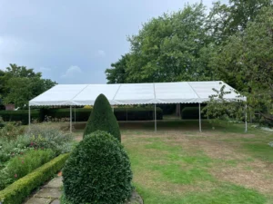Large Marquee with no sides in a garden.