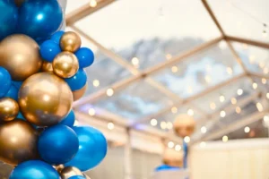 Close up of blue and gold balloon arch in marquee.