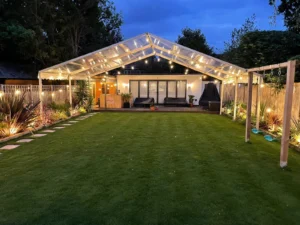 Marquee lit up with fairy lights in garden at night.