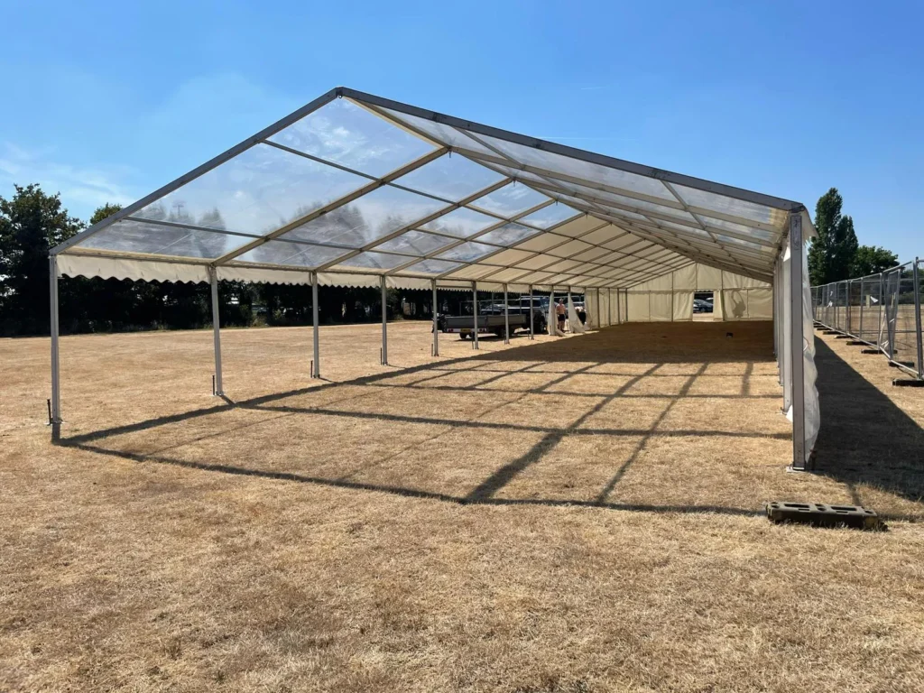 Marquee on a brown lawn ready for a corporate event.