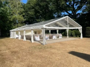 Wide angle of marquee on lawn set for lunch.