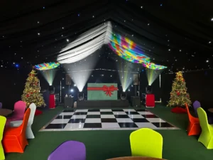 Marquee interior fully decorated with dance floor and props for a corporate party.