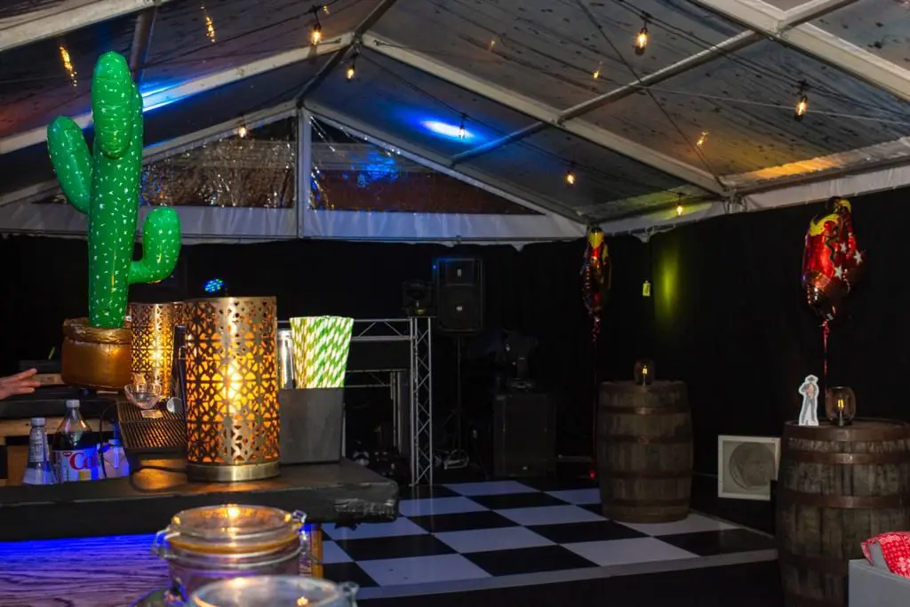 Clear span marquee with checkerboard dance floor and party props.
