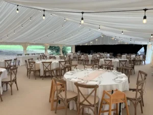 Luxury wedding marquee interior with draped ceiling and lighting