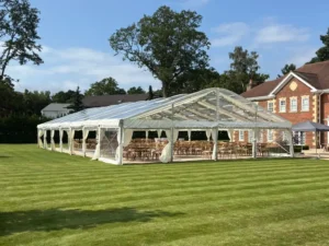 Luxury clearspan wedding marquee on manicured lawn outside an elegant historic building