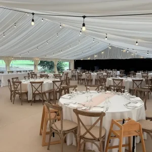 Luxury wedding marquee interior with draped ceiling and lighting