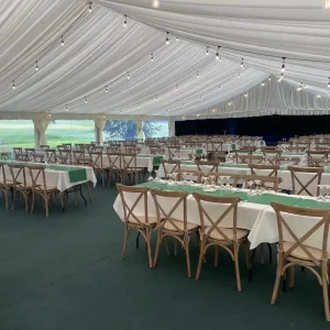 Interior of wedding marquee set up in banqueting style.