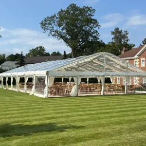 Luxury clearspan wedding marquee on manicured lawn outside an elegant historic building